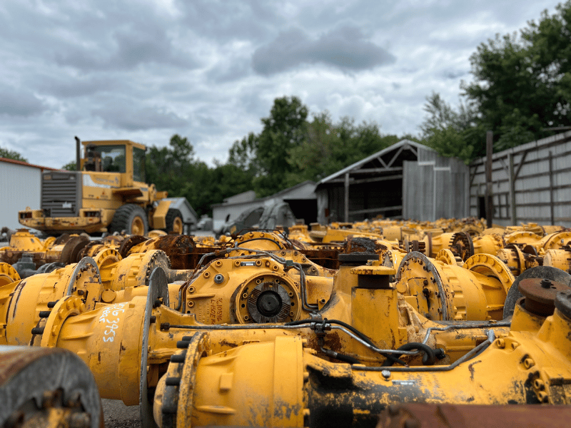 A heavy equipment salvage yard filled with used parts, all in yellow.